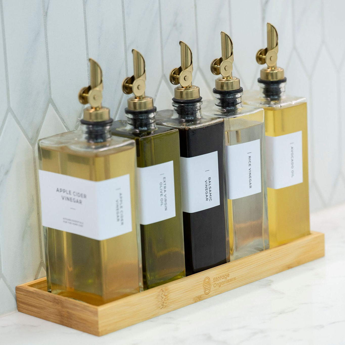Glass condiment bottles on bamboo tray for kitchen organisation